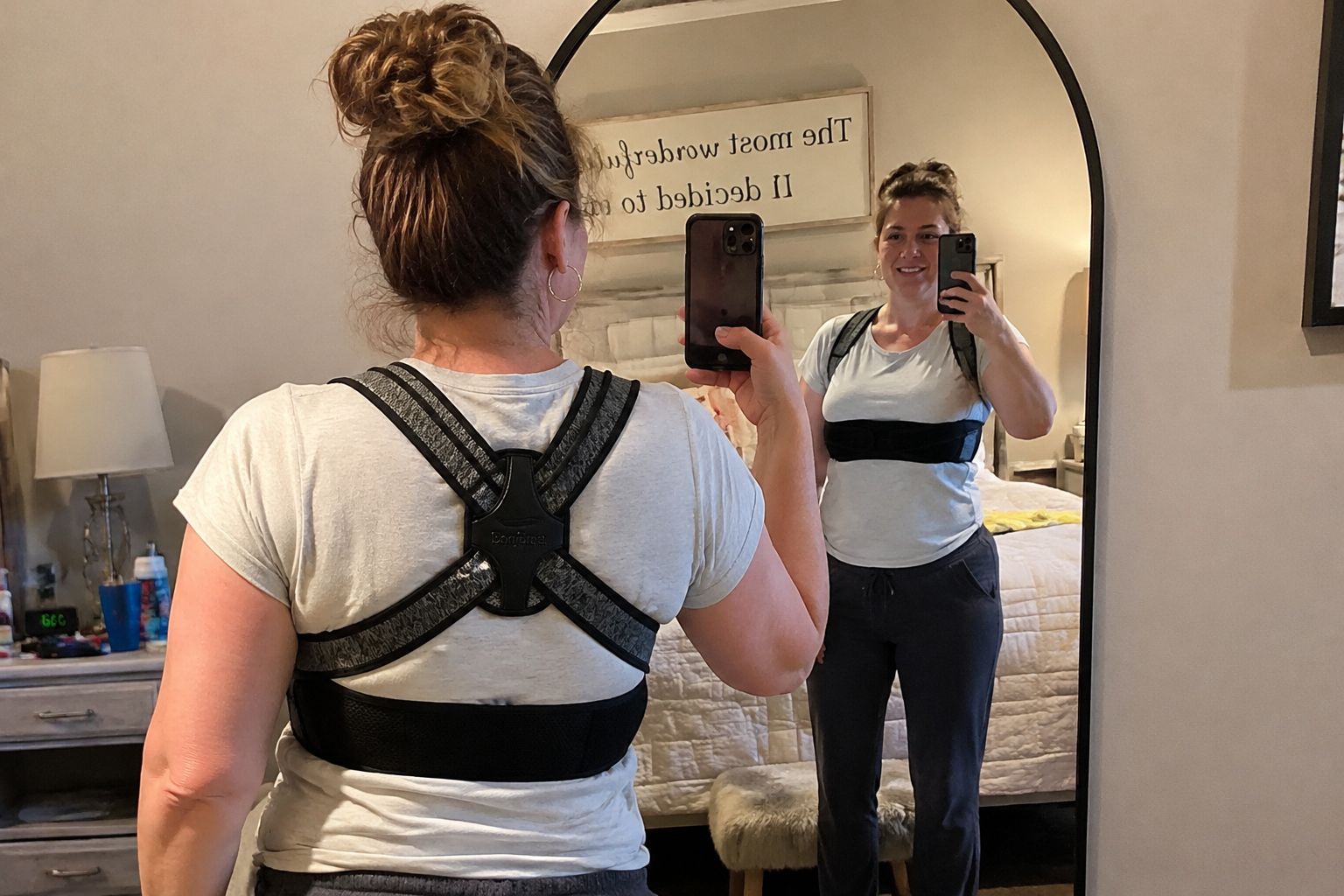 Woman wearing Enthra posture corrector sitting comfortably on bed after spine surgery